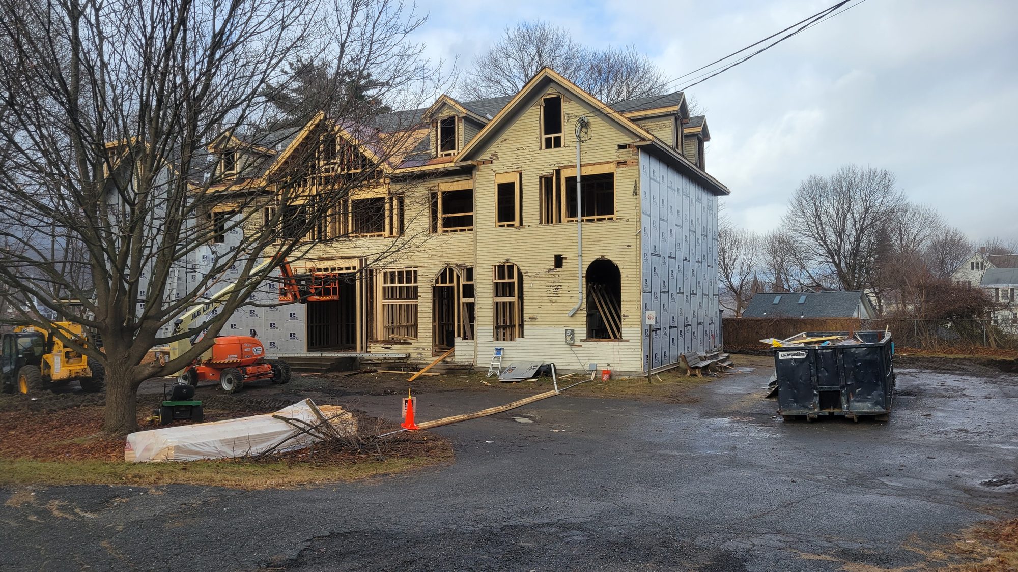 The building stripped to sheathing with new roof framing and dormers going up